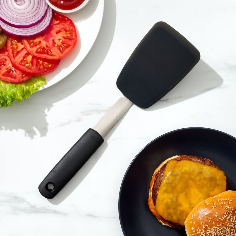 A burger setup with a spatula and plates