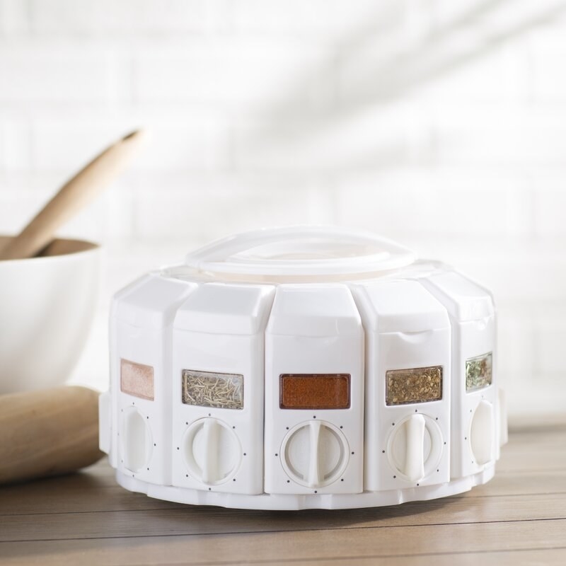A white round spice rack with a. measuring dial on it