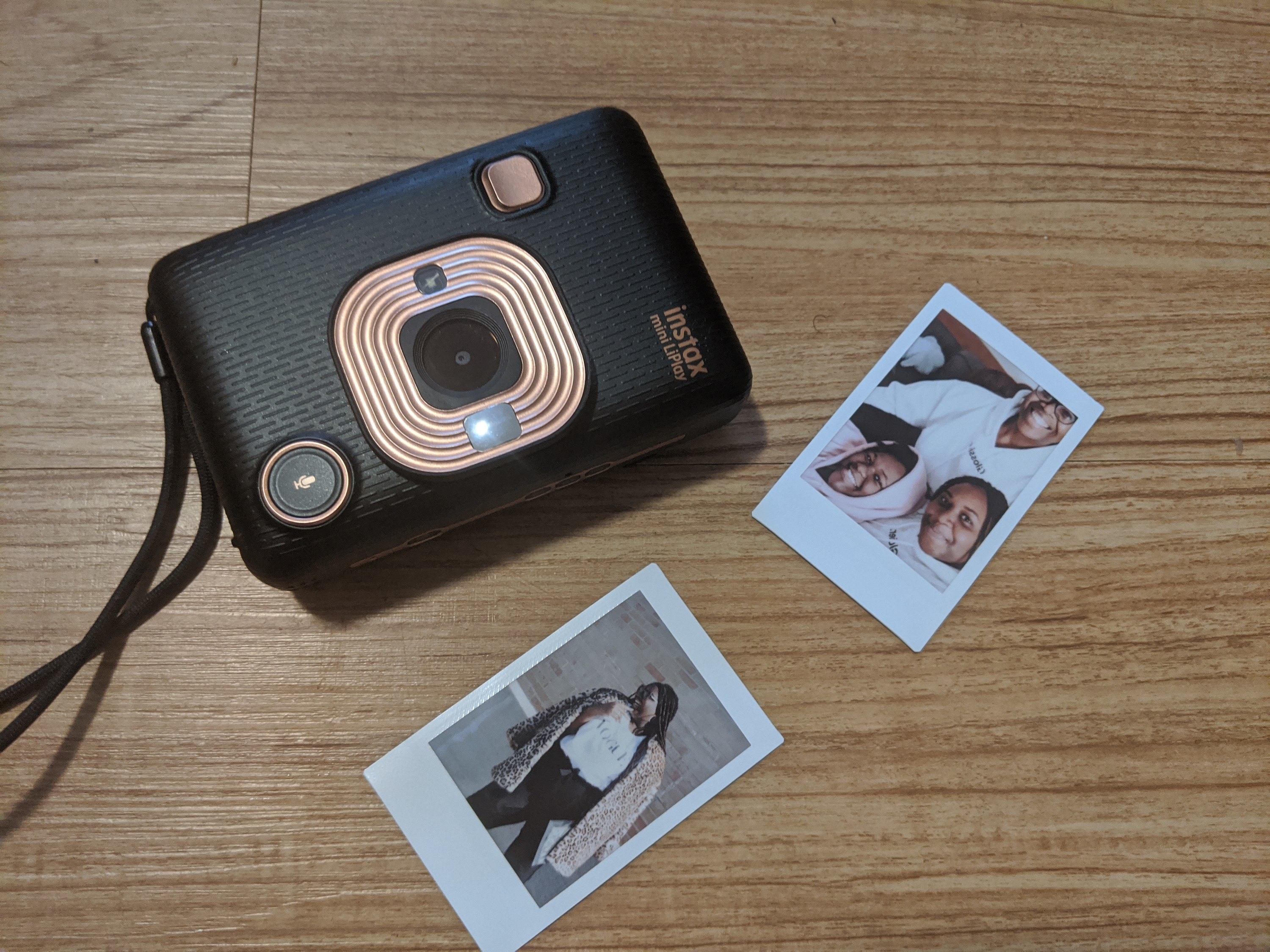 A small camera with two instant photographs beside it