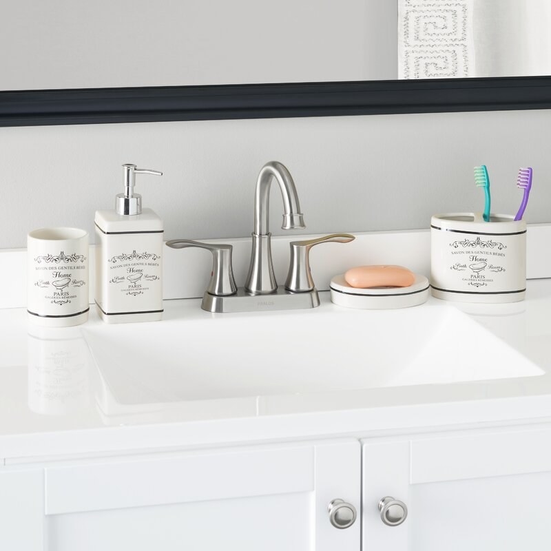A bathroom sink with white bathroom accessories