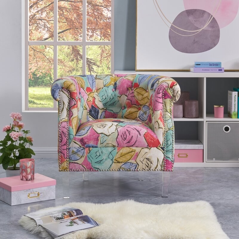An accent chair in a floral print with a faux fur rug