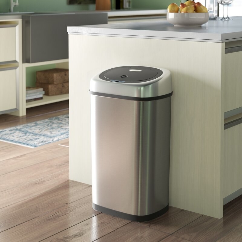 A kitchen with a stainless steel garbage can