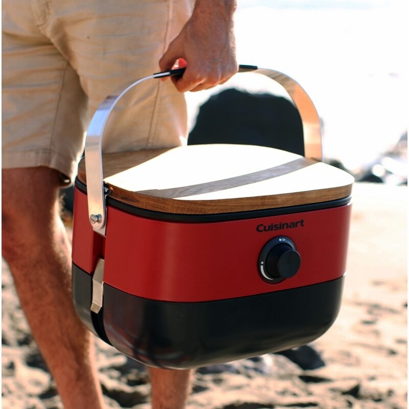 A man holding a Cusinart portable grill that looks like a cooler