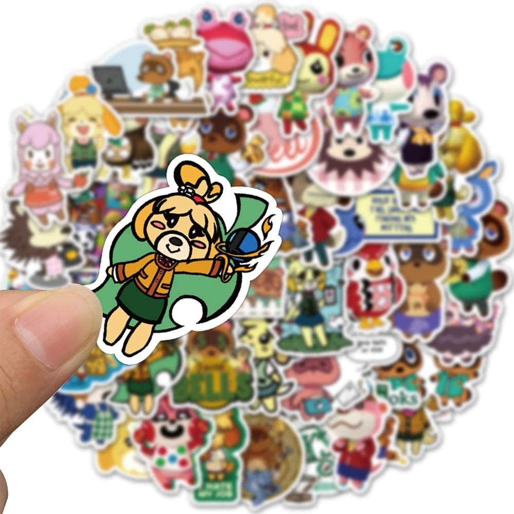 A person holding a sticker in their hand above a pile of other stickers