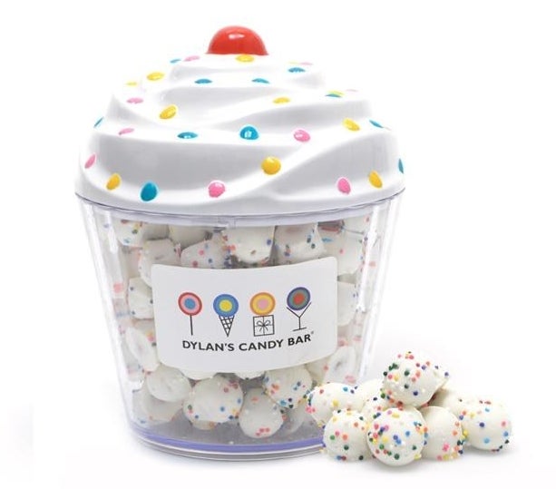 A plastic cupcake container with the balls covered in rainbow nonpareils inside