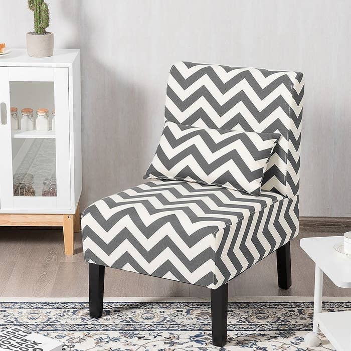 The gray and white armless chair with a matching lumbar pillow and black legs