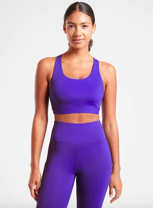 Model wears a blue-violet scoop neck sports bra with matching leggings