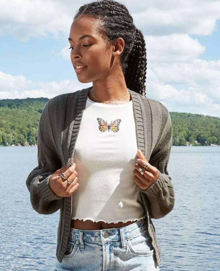 Model wearing gray short cardigan over butterfly tee