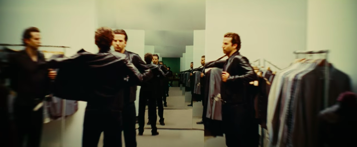 Bradley Cooper trying on a leather jacket, which is reflected multiple times