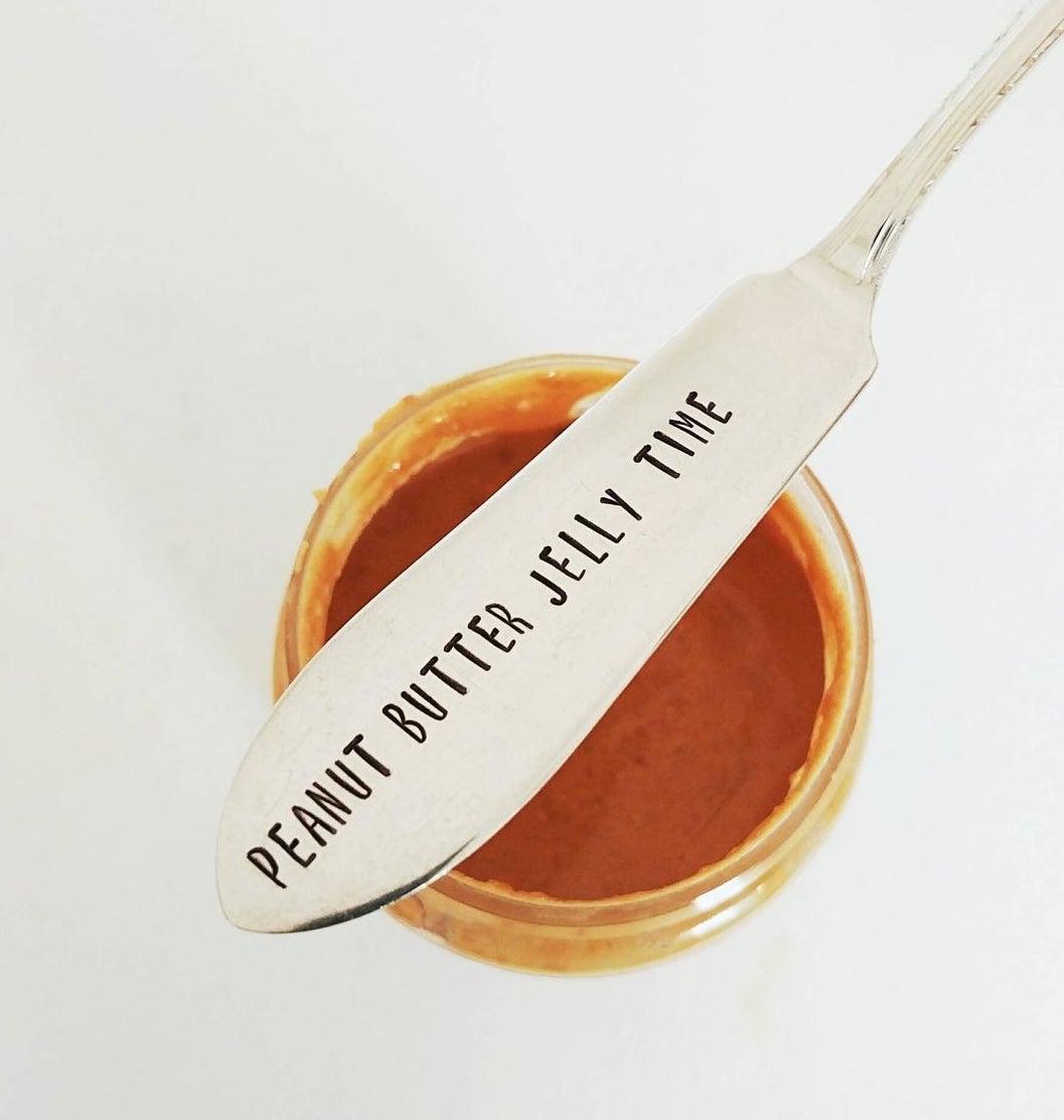 The spreader knife on top of a jar of peanut butter