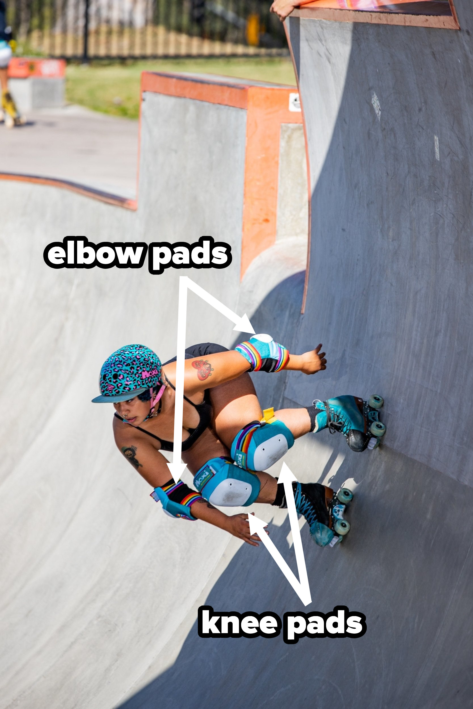 A model roller skater wearing elbow and knee pads on a ramp at a skate park