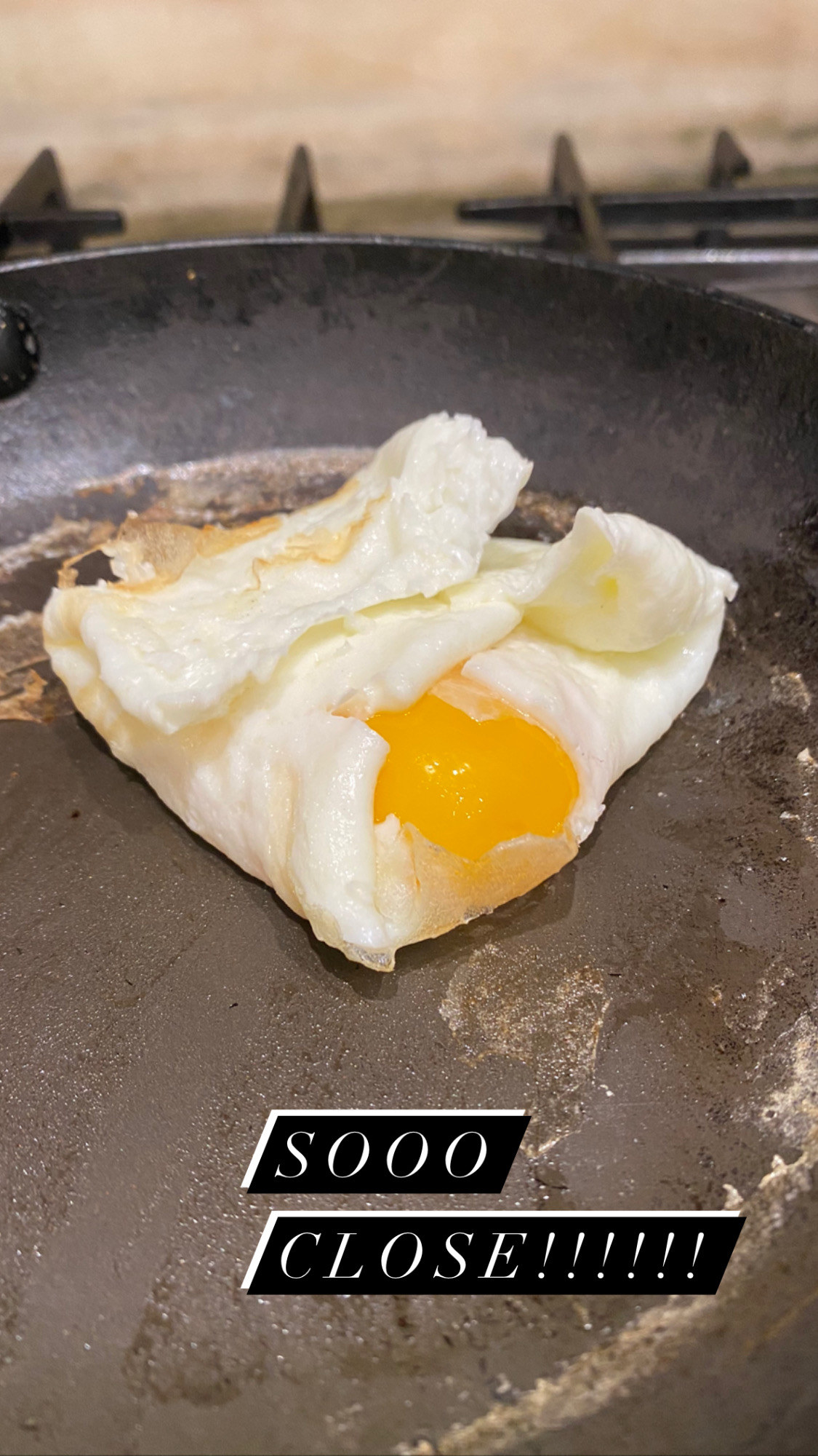 An egg yolk falling out of the egg white envelope.