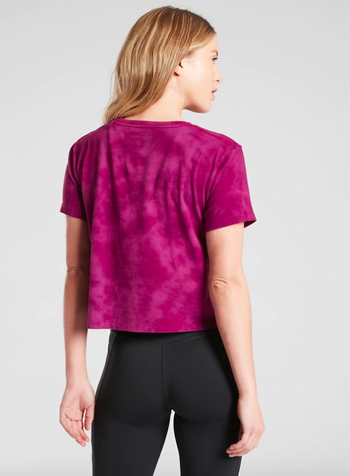 Model wears pink tie-dye short-sleeve crop tee with black leggings