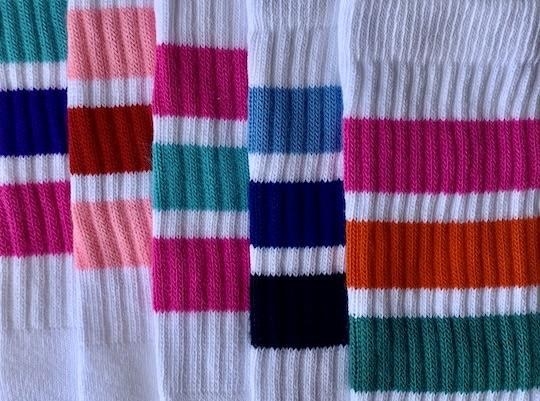 14-inch white tube socks with three stripes layered on top of each other