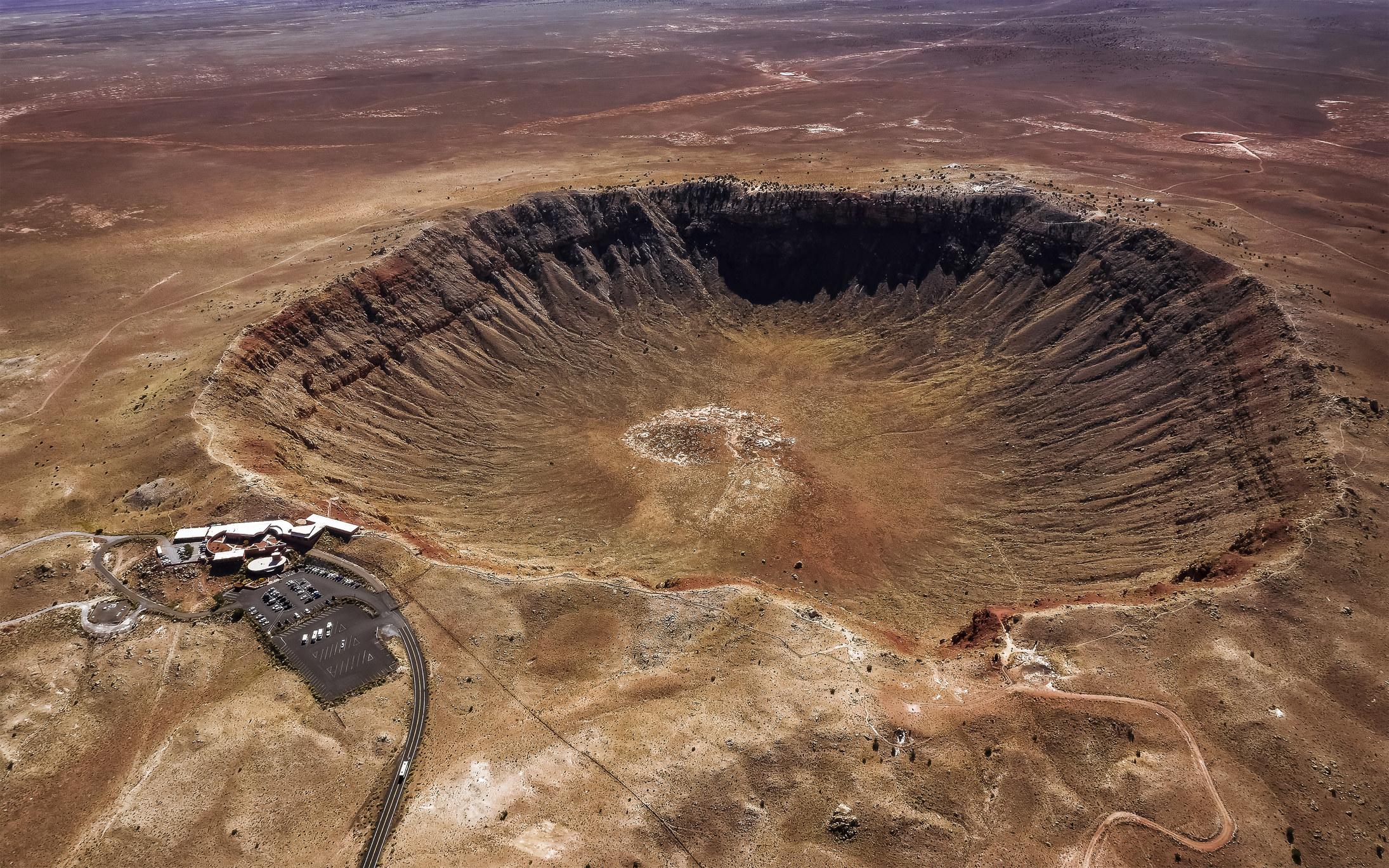 bird's-eye view of a giant crater with rippled edges in the ground