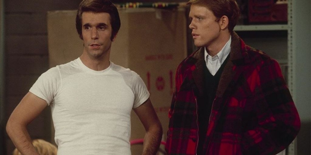 Fonzie puffing his chest next to another white man.