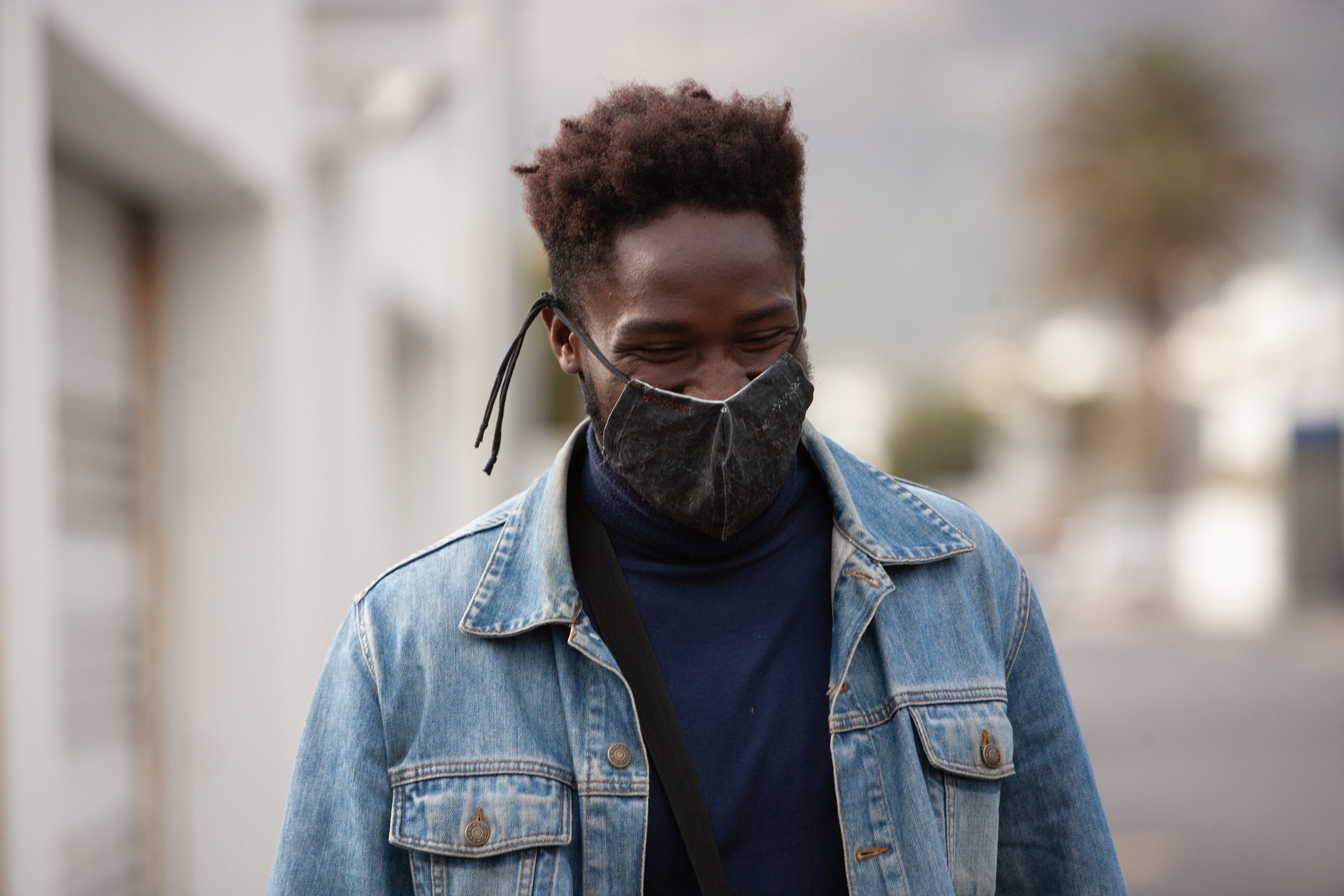 Une personne portant une veste de jeans et un masque avec des boucles latérales réglables.