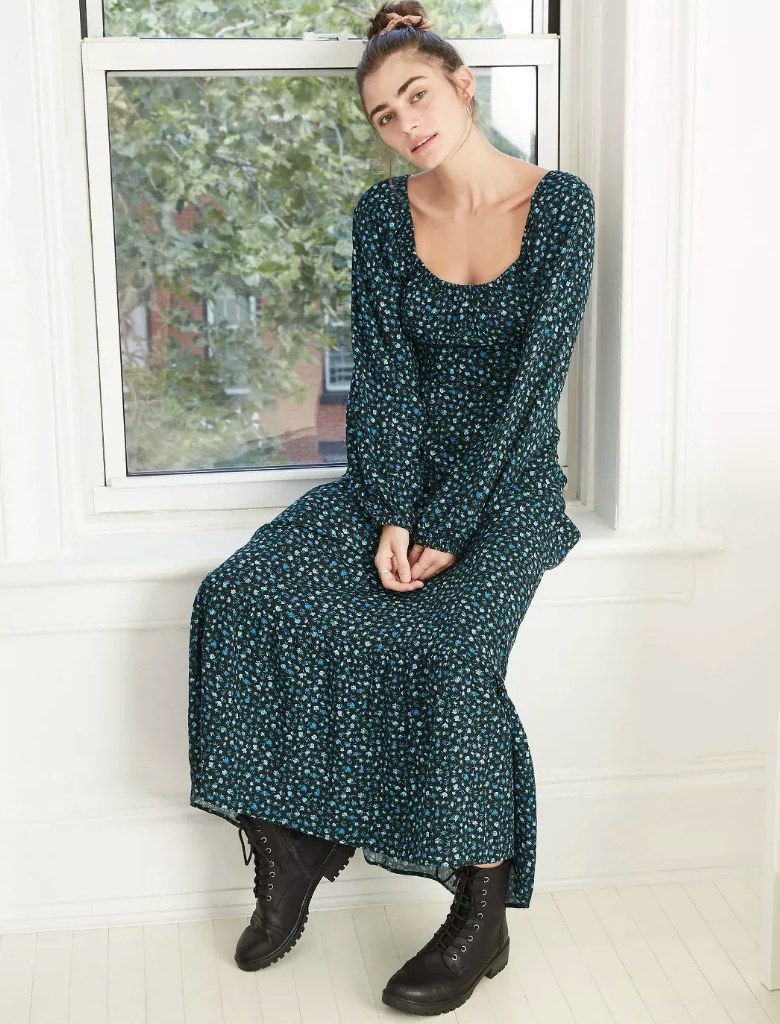 Model wearing deep blue long sleeve/floor length floral dress with black combat boots