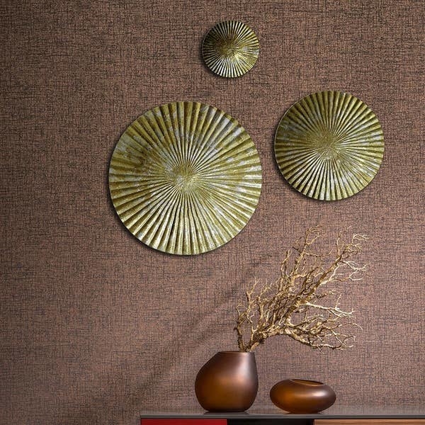Pleated round metal wall decorations with a chipped, antique golden and silver paint.
