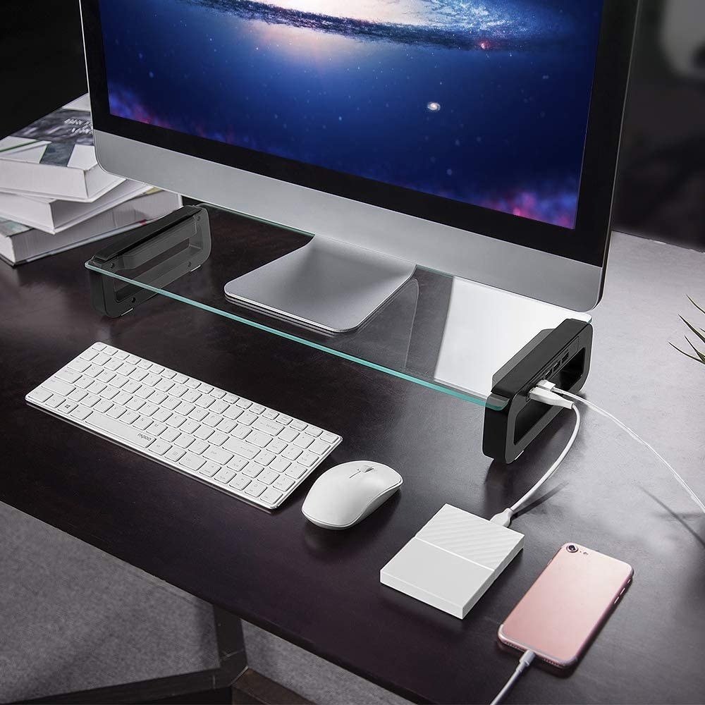 The monitor stand with devices plugged into its side