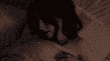 A gif of Emily lying down in her bedroom when suddenly all of the power goes out.