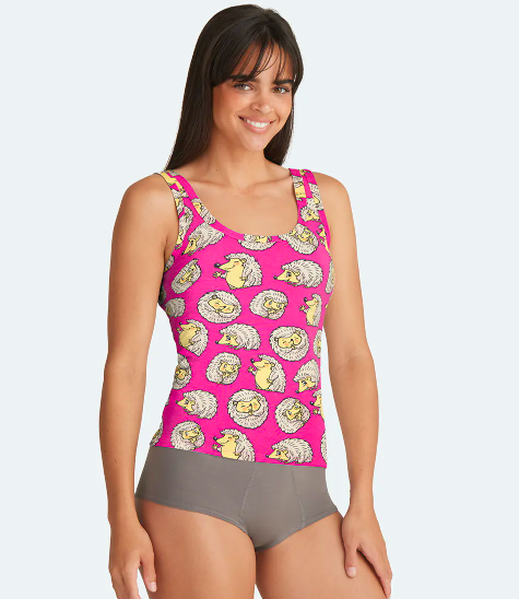 A model wearing the pink scoop neck tank printed with yellow hedgehogs with different expressions