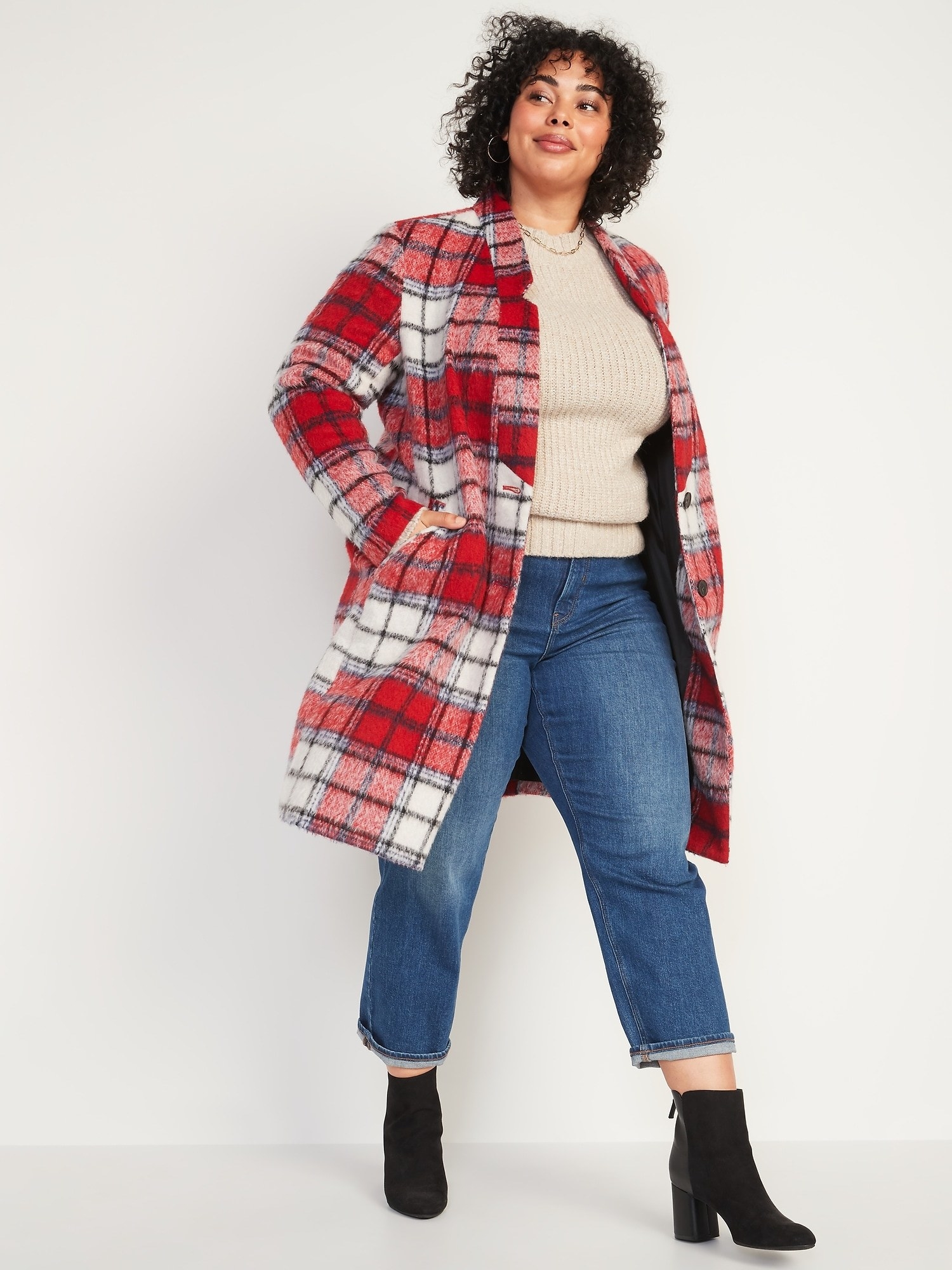 A model wearing the red and white plaid coat that hits just above the knee with jeans and booties