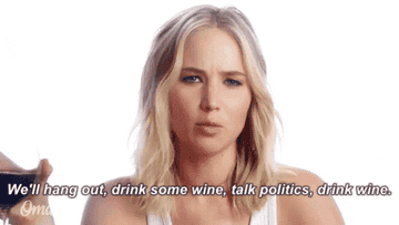 Jennifer Lawrence holding a glass of wine and talking