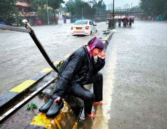 A man cries on the street while it rains