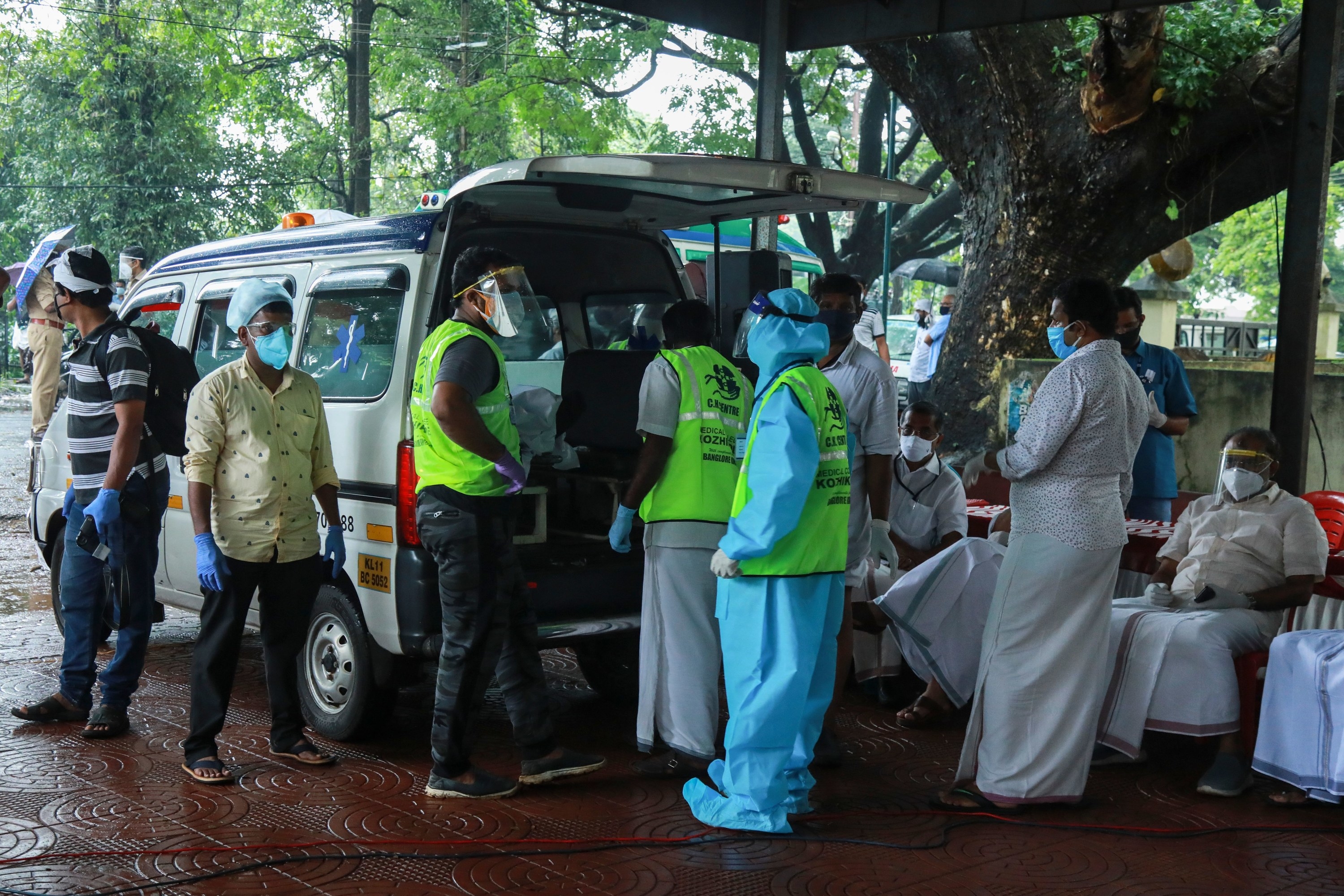 Medical staff wearing Personal Protective Equipment (PPE) equipment prepare to carry the body of a victim inside the medical college where Air India Express jet crash victims are taken for the post-mortem examination in Kozhikode, Kerala