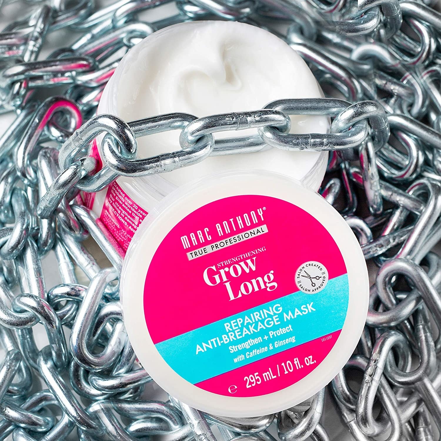 A tub of the hair mask on a pile of chains