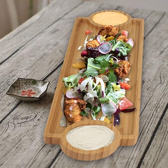 Rectangular bamboo tray with food and dips on it