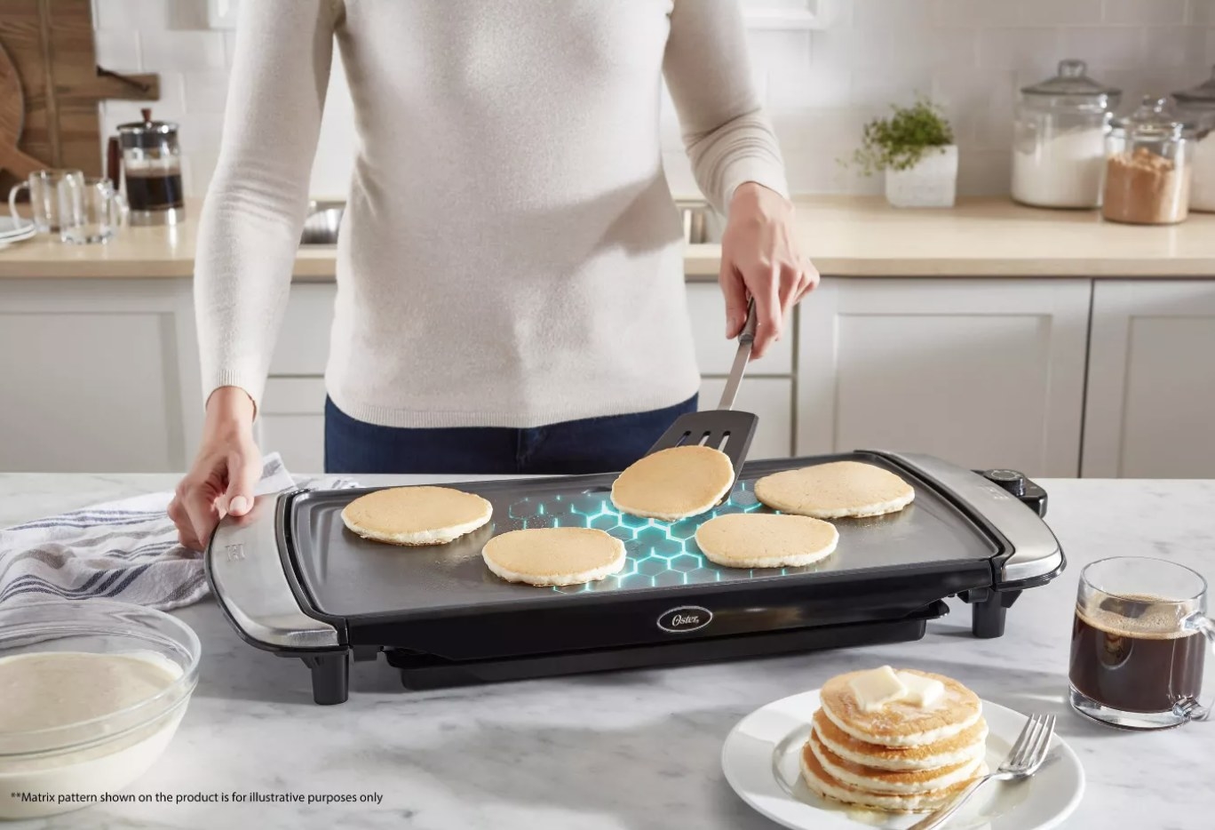 Person is flipping a pancake on an electric griddle