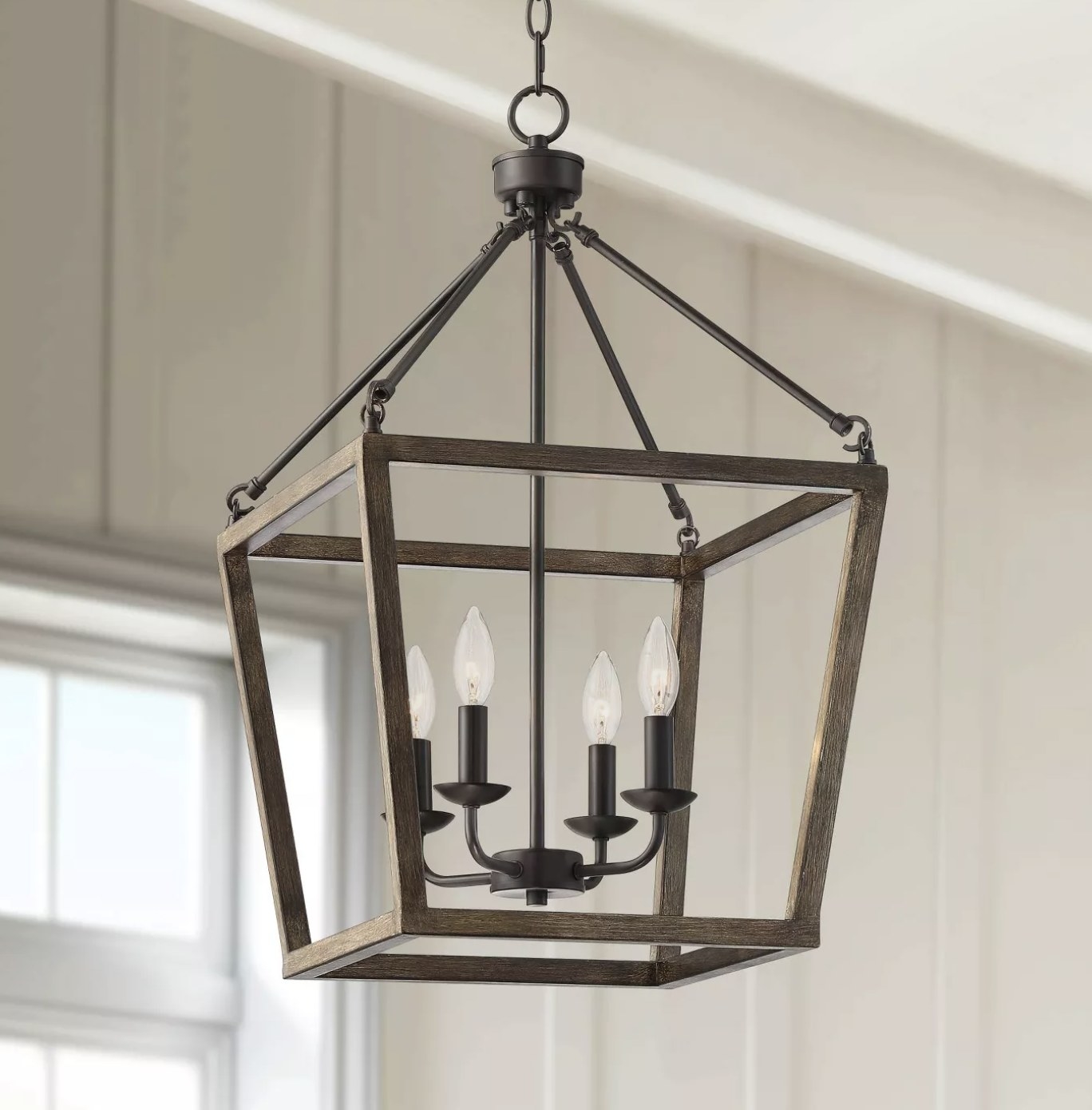 A rustic chandelier with four candlelights inside