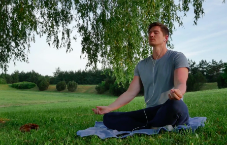 A person sits in a field and meditates