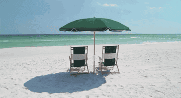Two beach chairs sitting in front of the shore