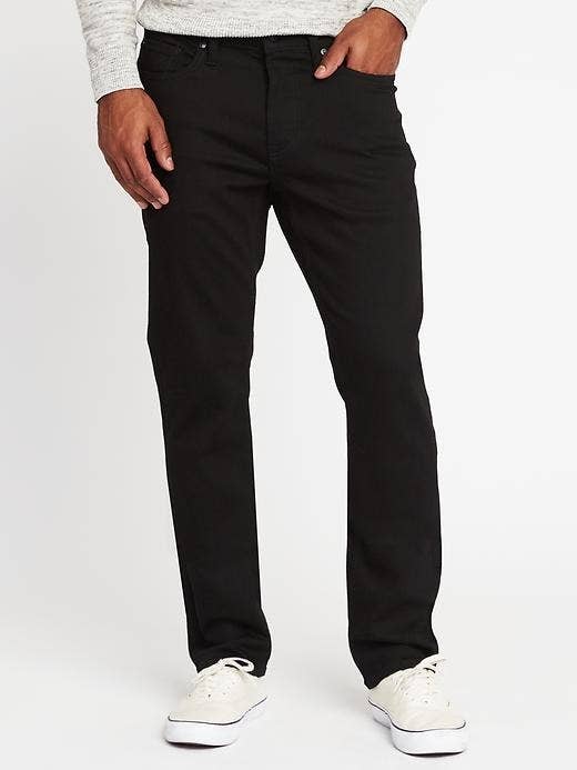 Model wearing the jeans with a long-sleeved shirt tucked in and off-white sneakers