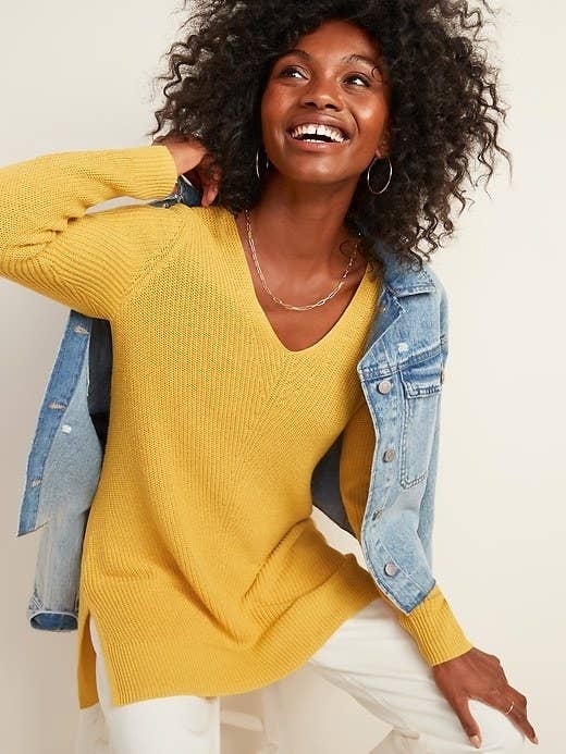 Model wearing the sweater in yellow under a blue jean jacket