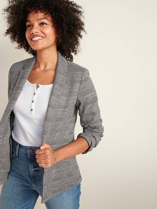 Model wearing the blazer over a white shirt tucked into blue jeans