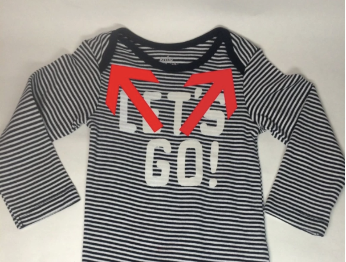 A onesie with arrows pointing to the shoulder straps which stretch so the onesie can be pulled down off the baby