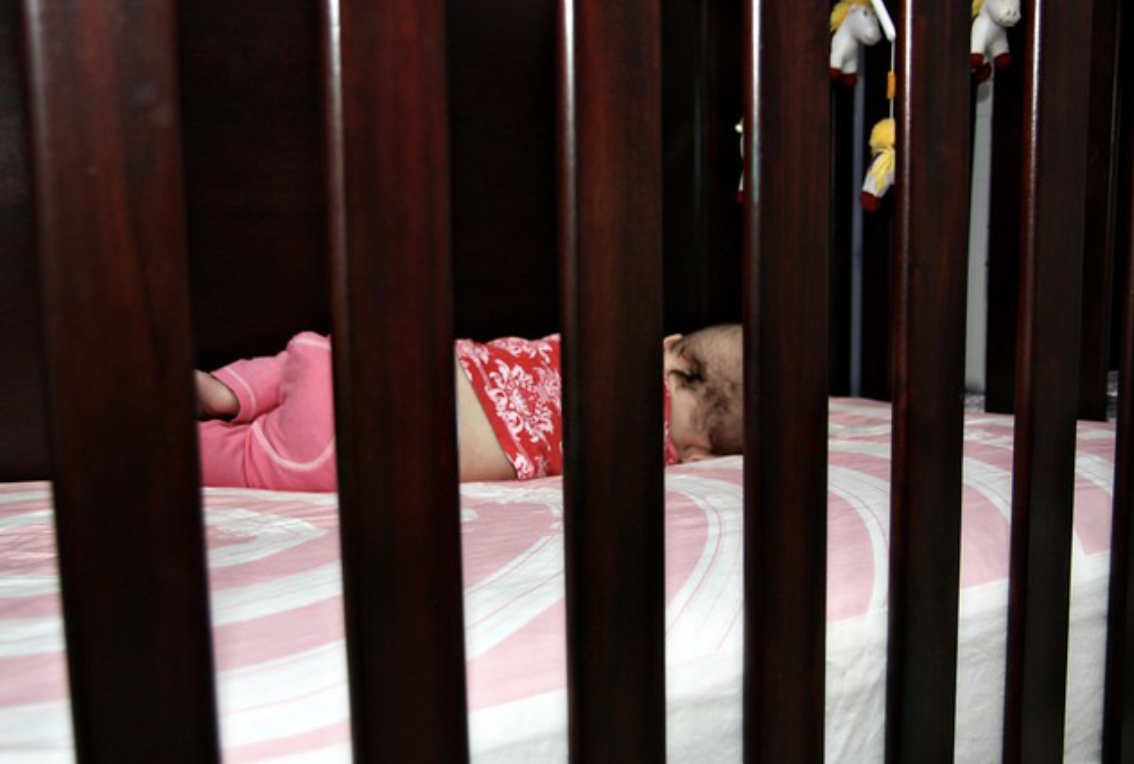 A baby sleeps in a crib