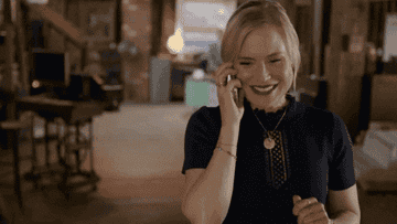gif of a woman looking happy and excited on the phone 