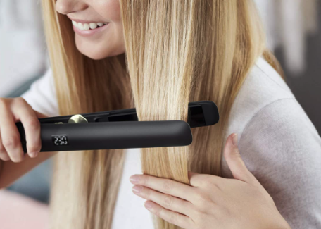 A woman using the Phillips hair straightener 
