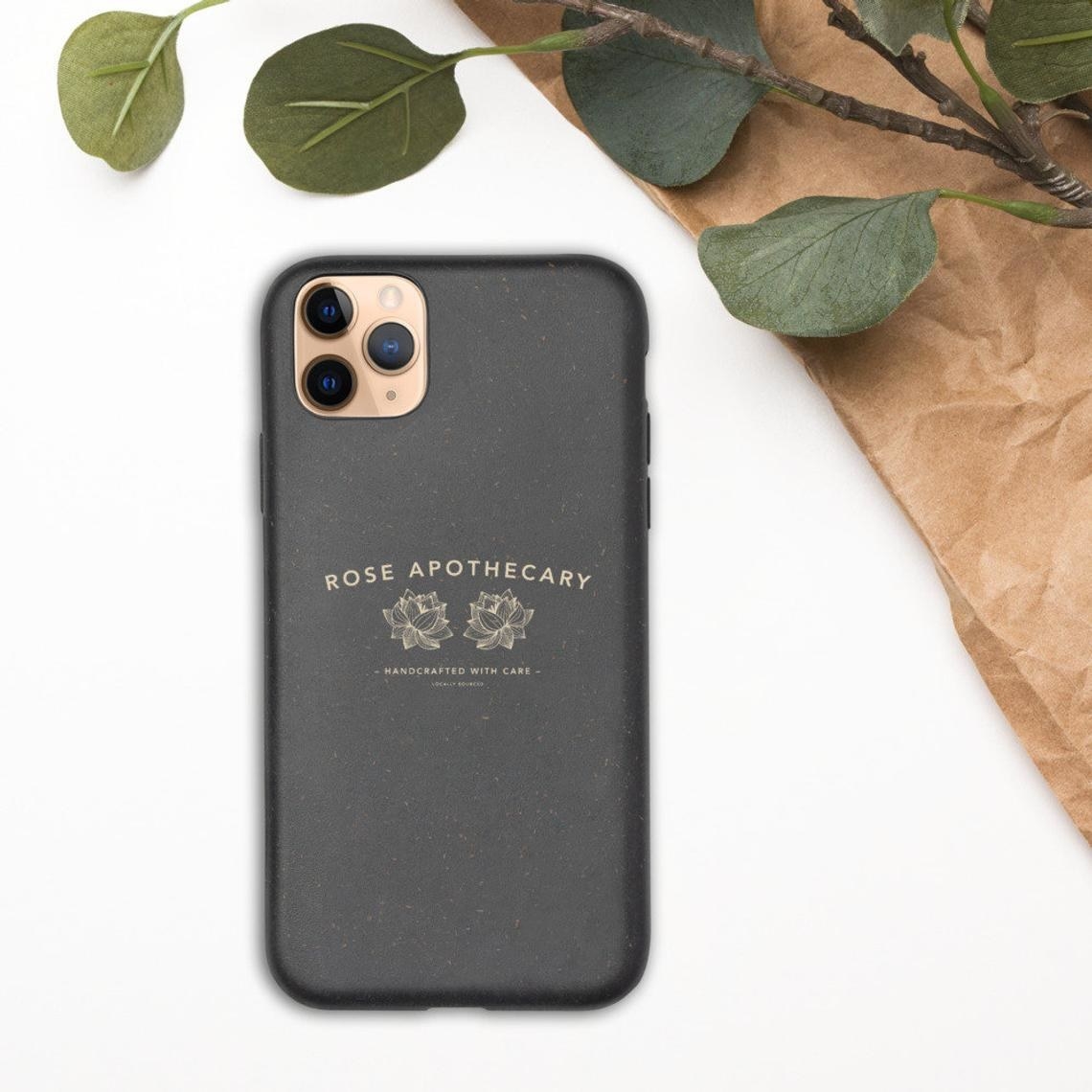 The case on a phone next to a plant and paper bag