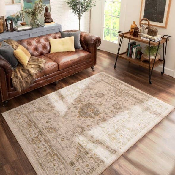 Living room with leather couch and beige distressed vintage rug