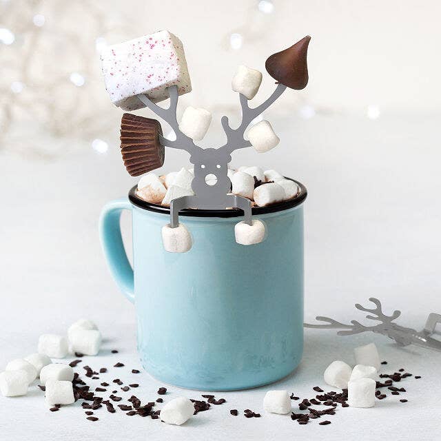 The caribou in a mug with marshmallows, Hershey's kisses, and mini Reese's on the prongs of its antlers