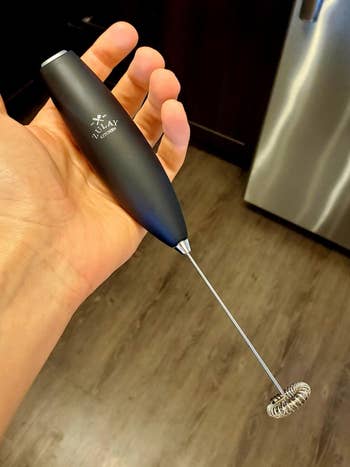 Reviewer holding the black milk frother