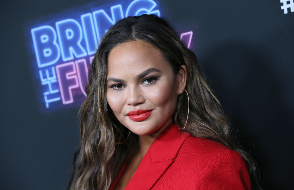 Chrissy Teigen in a blazer with bright lipstick