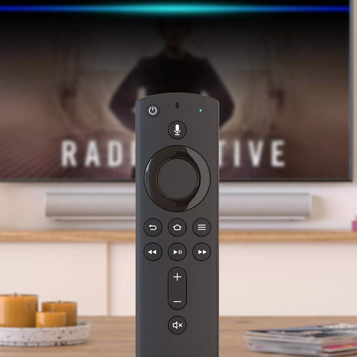 The Amazon Fire TV Stick with Alexa voice remote in front of a TV
