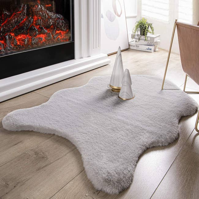 The curved edge (like a pelt) rug in white